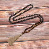 Meditation necklace with 108 beads and tassel on a wooden surface